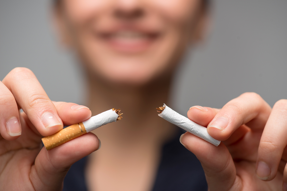 close up of woman's hands breaking cigarette in half