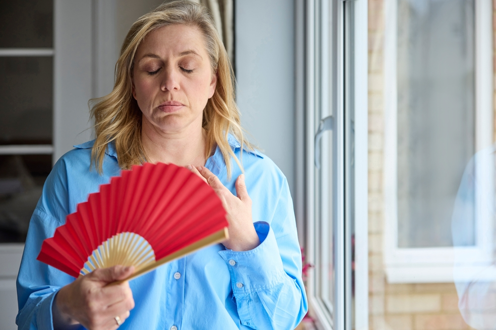 menopausal woman fanning herself during hot flash