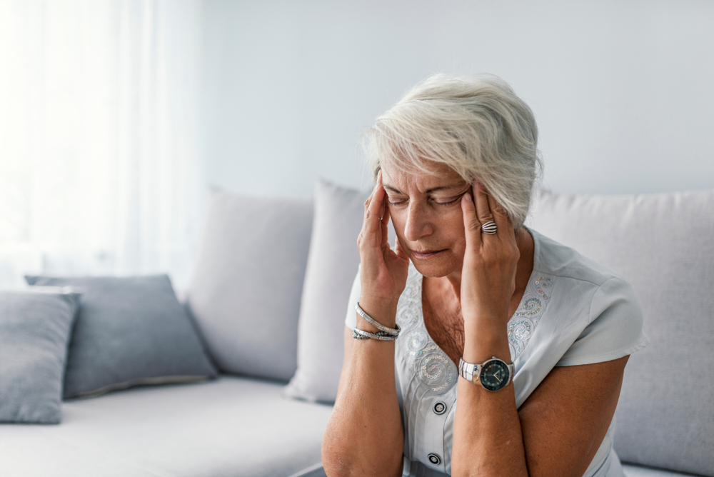 senior woman with headache holding her temples